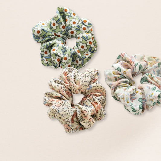 Three floral scrunchies for fine hair on a beige background