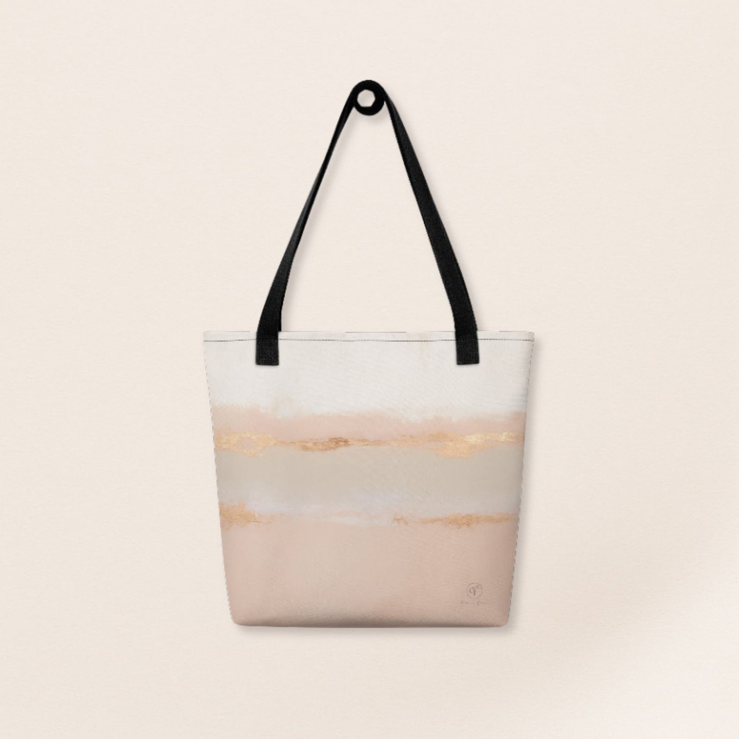 Beige and blush abstract tote bag with gold brushstroke accents and black handles on a beige background.