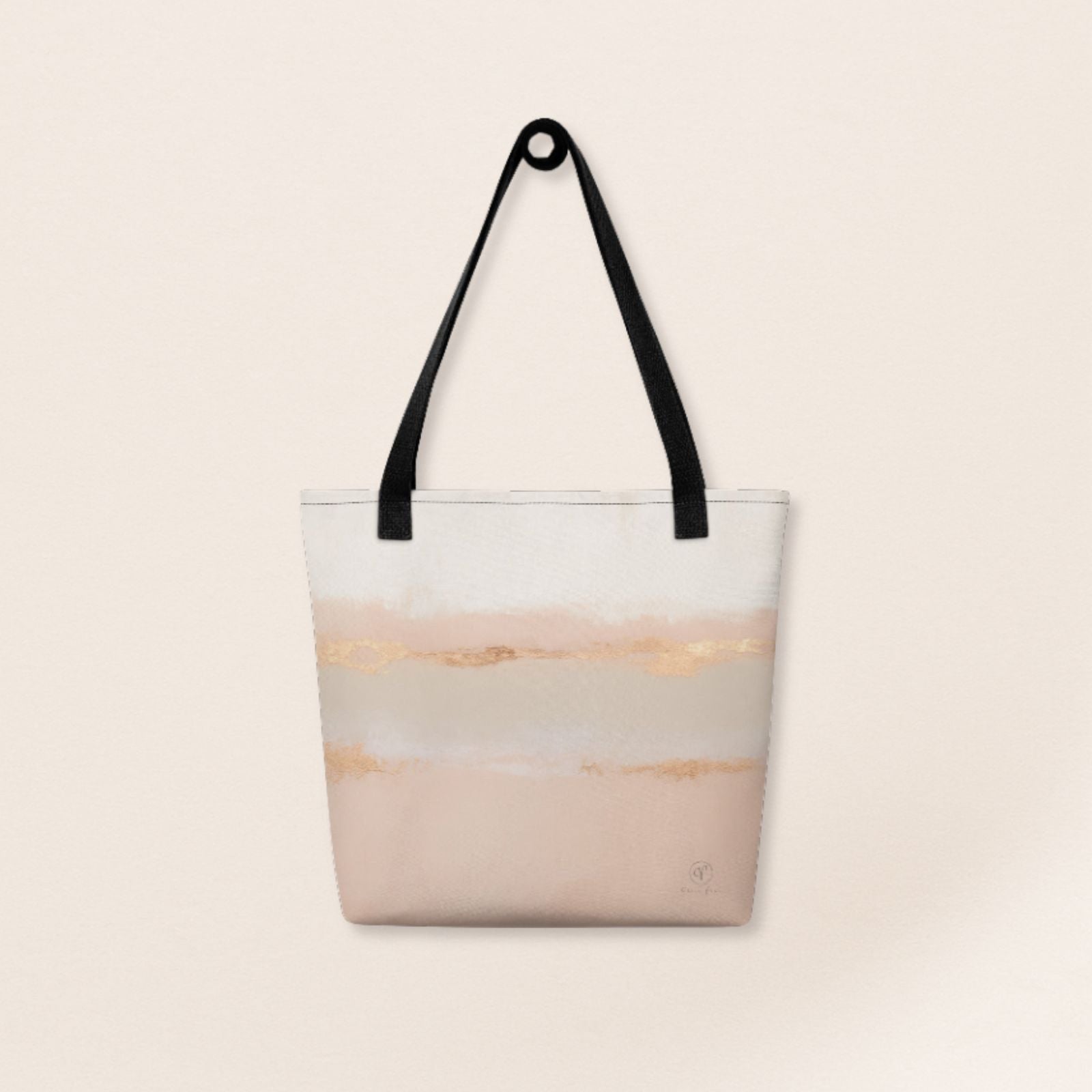 Beige and blush abstract tote bag with gold brushstroke accents and black handles on a beige background.