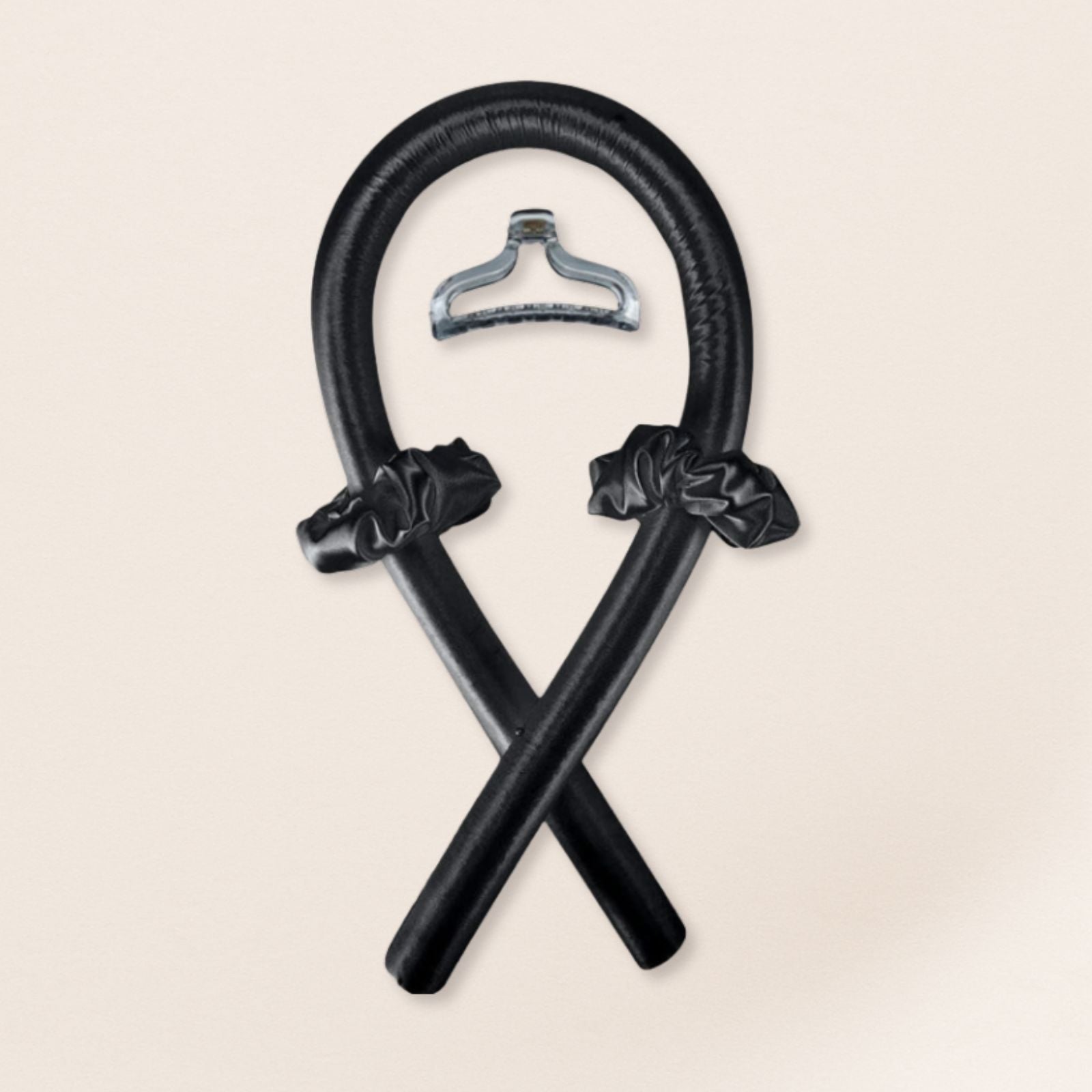 black heatless curling set with matching satin scrunchies and a black clip on a beige background