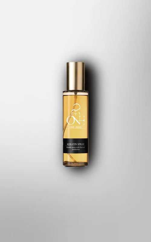 Gold and black hair spray bottle for fine hair on a light gray background