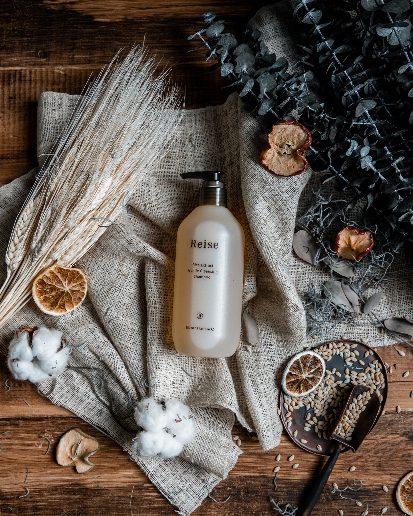 Reise shampoo bottle on a textured surface with dried elements