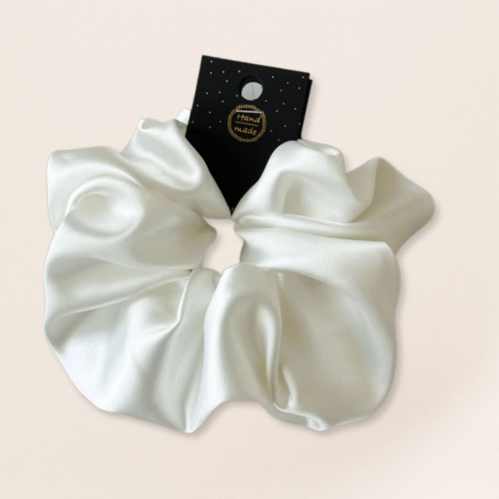 White satin scrunchie for fine hair on a beige background
