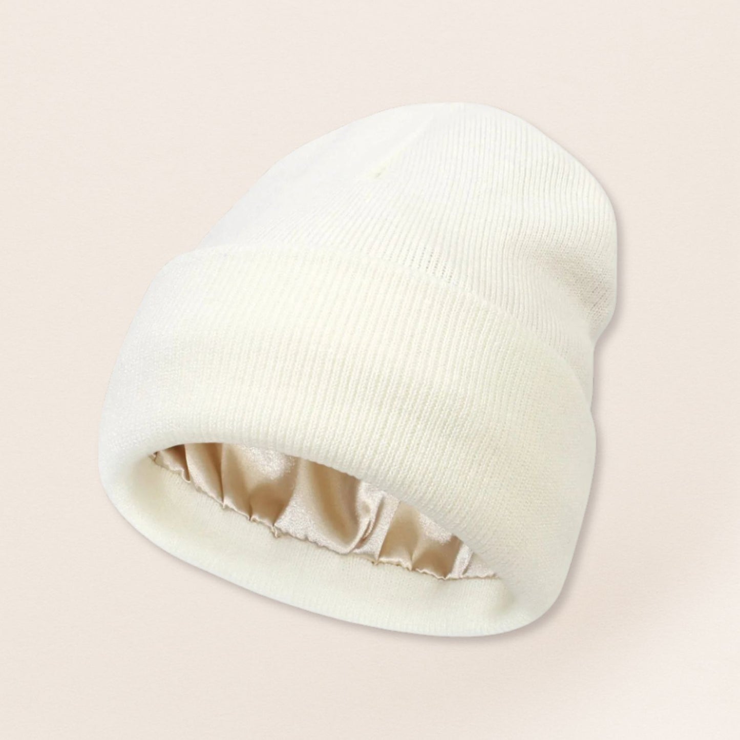white beanie with satin interior on a beige background