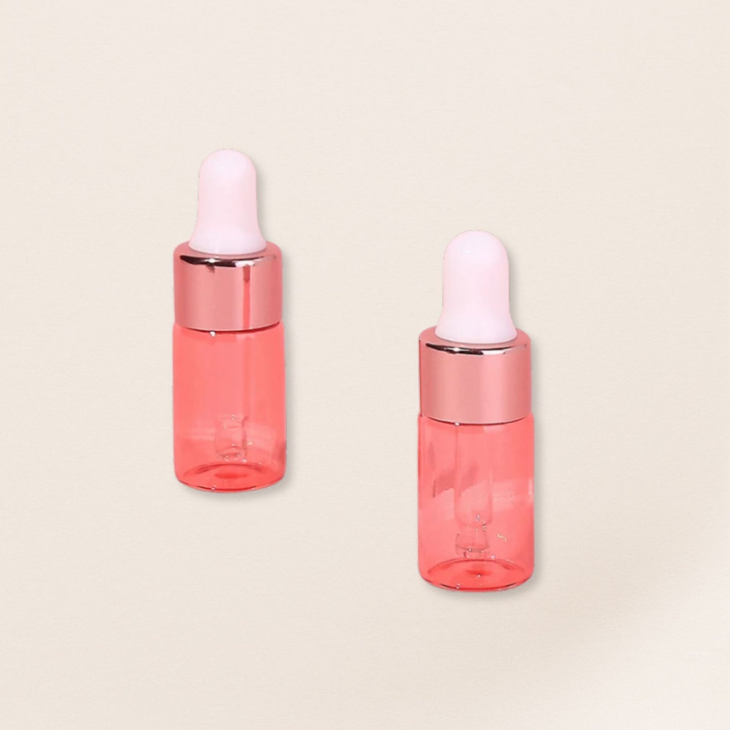 Two pink dropper bottles with white caps on a beige background