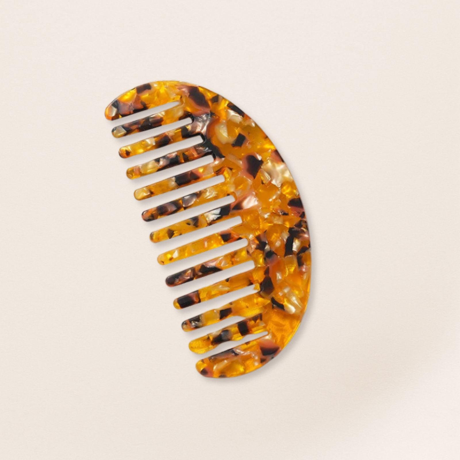 Lightweight yellow marbled half-moon comb for fine hair on a beige background.