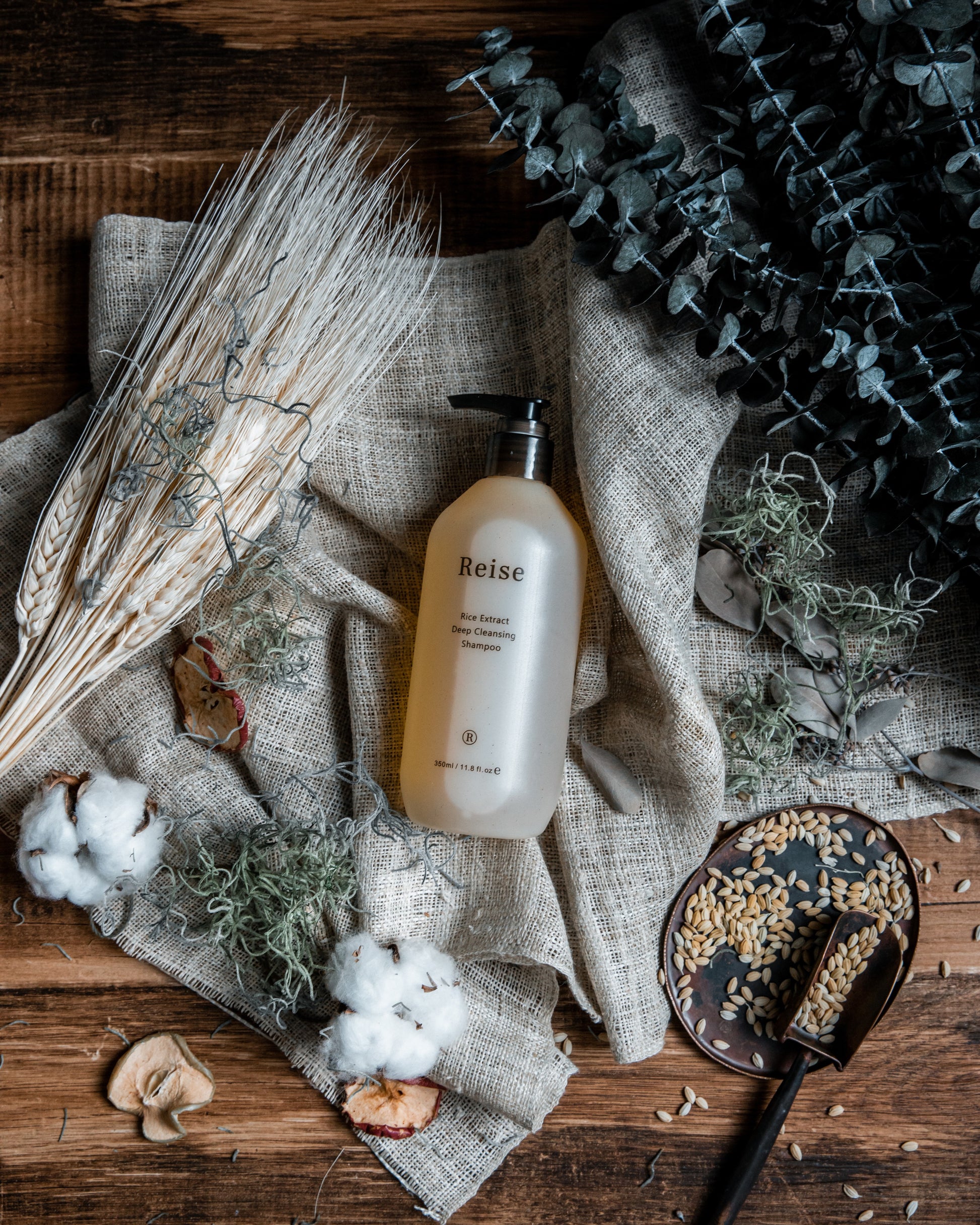 Reise haircare bottle on a rustic wooden surface with natural elements